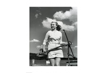 Young woman standing on boat, holding anchor